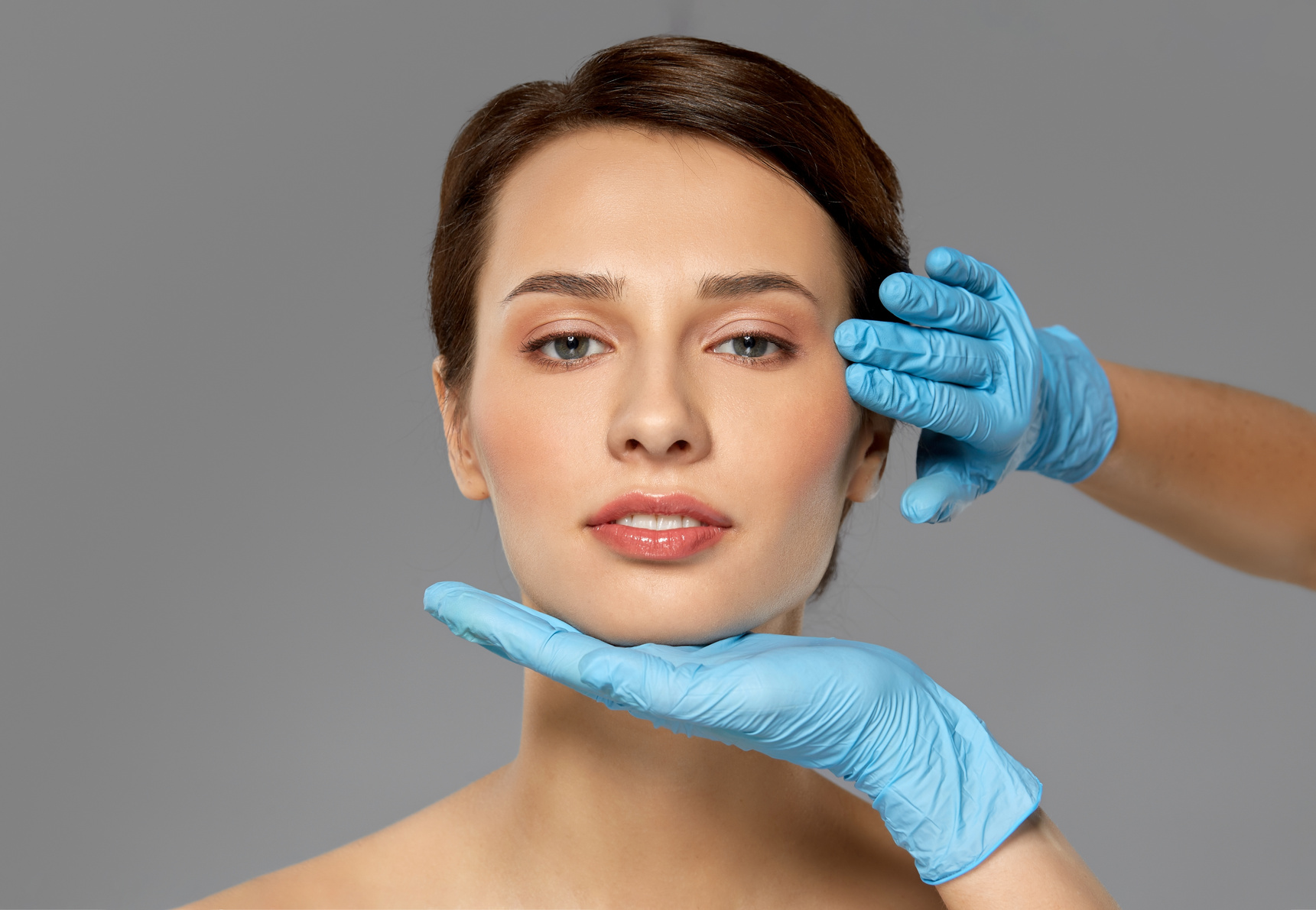 Hands with Gloves Touching a Woman's Face